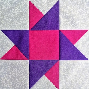 May include: A quilt block with a star design. The star is made of pink and purple fabric, and the background is white with a swirling pattern.
