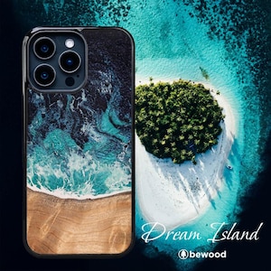 Op de afbeelding: Een telefoonhoesje met een ontwerp van hout en hars met een blauw en wit oceaangolvenpatroon. Het hoesje heeft een zwarte rand en een camera-uitsparing. De achtergrondafbeelding toont een tropisch eiland met weelderige groene bomen en wit zand.
