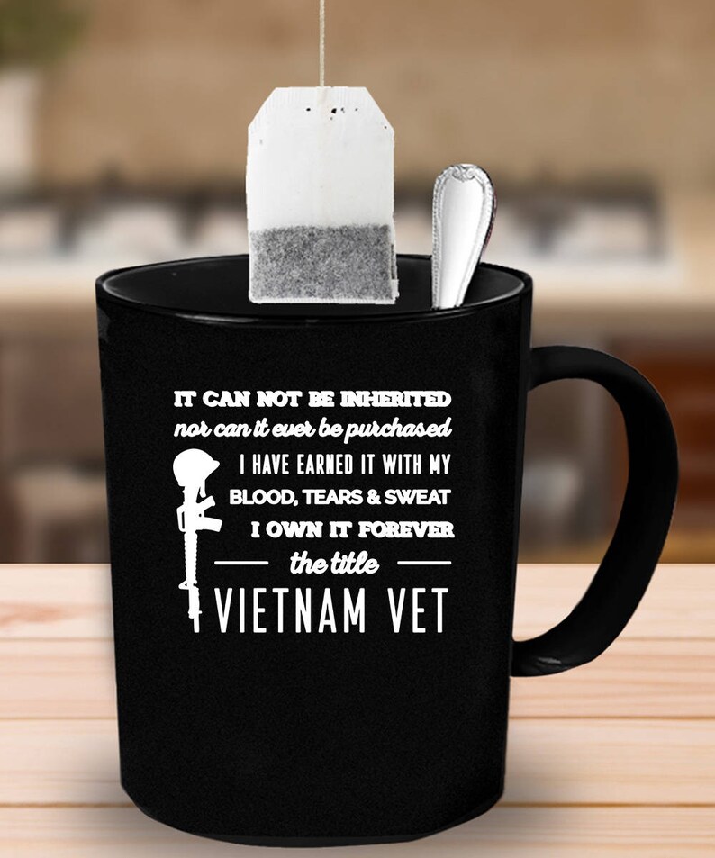 May include: Black ceramic mug with a white graphic and text. The text reads "IT CAN NOT BE INHERITED nor can it ever be purchased I HAVE EARNED IT WITH MY BLOOD, TEARS & SWEAT I OWN IT FOREVER the title VIETNAM VET."