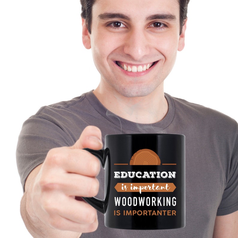 May include: A black coffee mug with a white design that reads "EDUCATION is important WOODWORKING IS IMPORTANTER". The mug has a brown wood grain design and a white steam coming from the top.