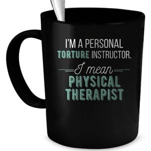 May include: Black coffee mug with a white inscription that reads "I'm a personal torture instructor. I mean physical therapist".