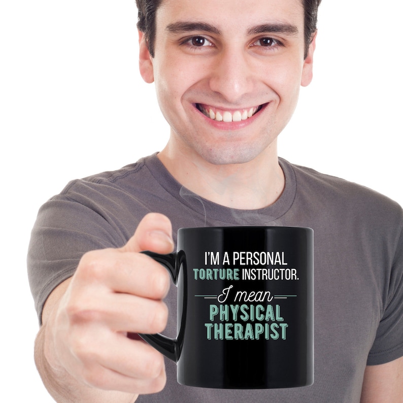 May include: A black coffee mug with white text that reads "I'm a personal torture instructor. I mean physical therapist."