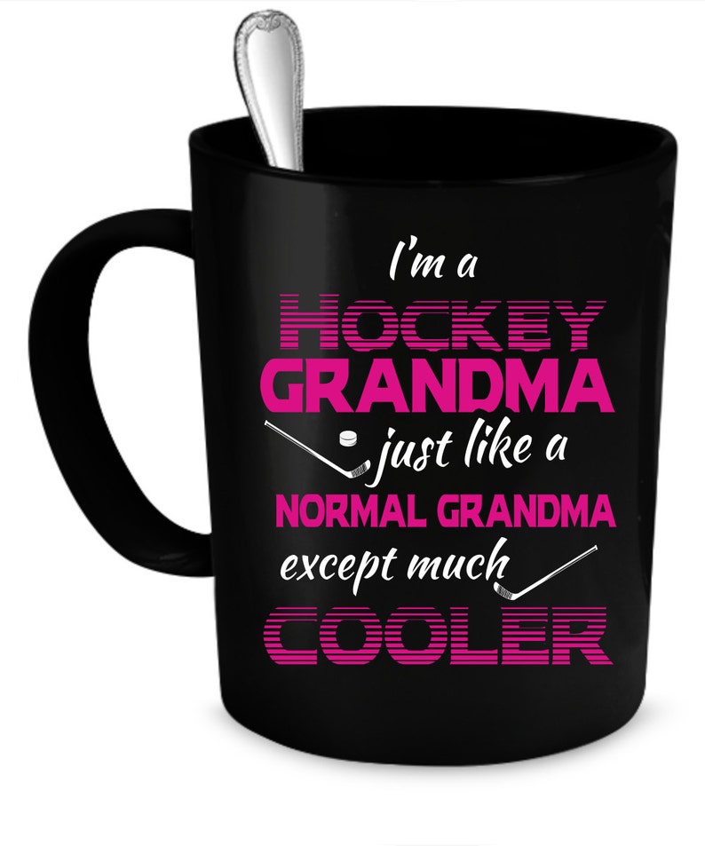 Puede incluir: Taza de caf&eacute; negra con un dise&ntilde;o rosa y blanco que dice "Soy una abuela de hockey como una abuela normal, excepto mucho m&aacute;s genial".