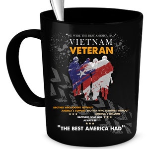 May include: Black ceramic mug with a silver spoon inside. The mug features the words "VIETNAM VETERAN" in yellow and white, along with a graphic of soldiers draped in the American flag. The text "WE WERE THE BEST AMERICA HAD" is also printed on the mug.