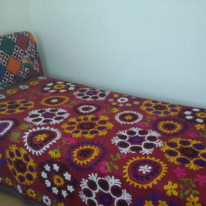 Puede incluir: Una manta de tiro bordada en rojo, blanco y azul con un patr&oacute;n floral. La manta est&aacute; hecha de algod&oacute;n y es perfecta para agregar un toque de color y estilo a cualquier habitaci&oacute;n.