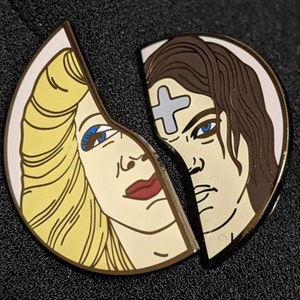 May include: A split enamel pin featuring two faces, one with blonde hair and blue eyes, the other with brown hair and blue eyes. The face with blonde hair is smiling, while the face with brown hair has a serious expression. A white cross is on the forehead of the face with brown hair.