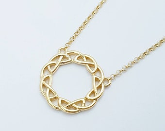 Op de afbeelding: Een gouden ketting met een Keltische knoop hanger. De hanger is een cirkel met een knoop ontwerp.