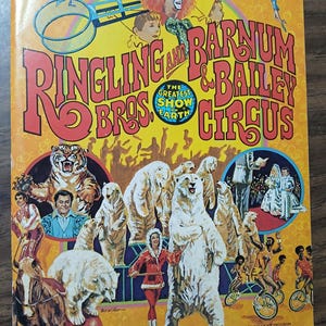 May include: A vintage Ringling Bros. and Barnum & Bailey Circus souvenir program cover. The cover features a vibrant yellow background with the circus name in large, red letters. Illustrations include a tiger, polar bears, clowns, and acrobats. The text reads "The Greatest Show on Earth."