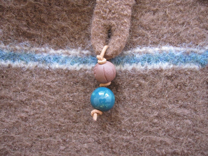 May include: A brown wool fabric with a blue and white stripe and a brown and blue bead necklace.