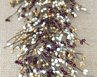May include: A long garland of berry sprigs with white, tan, and burgundy berries. The garland is made of artificial berries and branches.