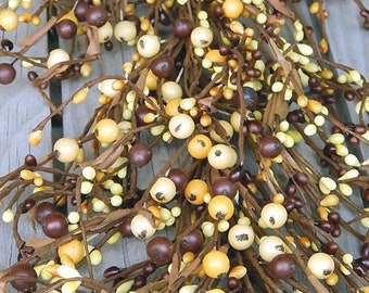 May include: A brown, beige, and yellow berry garland with brown stems. The garland is made of artificial berries and is perfect for adding a touch of fall decor to your home.