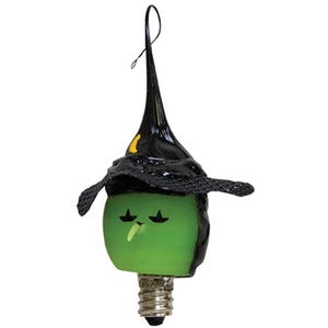 May include: A Halloween-themed light bulb ornament shaped like a witch. The bulb is green with a painted face and a black witch hat. The hat has a yellow accent and a loop for hanging.