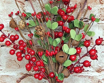 May include: A decorative floral arrangement featuring red berries, green leaves, small pinecones, and brown bell-shaped ornaments. The arrangement is tied together with a brown stem wrap, creating a festive and natural look.