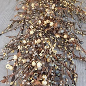 May include: A long, brown, twig-like garland with small, cream-colored and gray berries. The garland is perfect for adding a touch of rustic charm to your home decor.