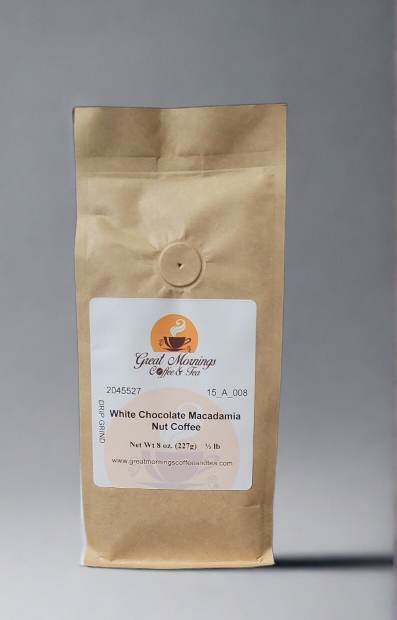 K&ouml;nnte beinhalten: Ein brauner Papierbeutel mit einem wei&szlig;en Etikett, auf dem "Great Mornings Coffee & Tea" und "White Chocolate Macadamia Nut Coffee" steht. Das Etikett enth&auml;lt auch den Text "Net Wt 8 oz. (227g) 1/2 lb" und "www.greatmorningscoffeeandtea.com".