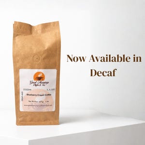 A kraft paper coffee bag labeled 'Blueberry Cream Coffee' by Great Mornings Coffee & Tea stands on a white surface against a white background, with large brown text on the right reading 'Now Available in Decaf'.