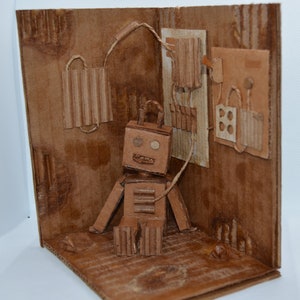 Recycled art, Dystopian Robot charging station, Made from recycled cardboard, miniature robot diorama Dystopia diorama Art