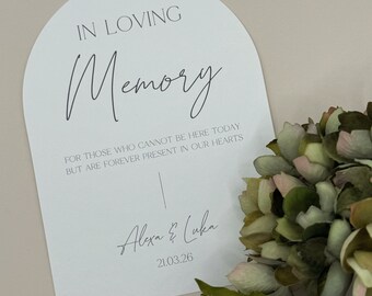 May include: White arch-shaped card with the text "IN LOVING Memory" and the message "FOR THOSE WHO CANNOT BE HERE TODAY BUT ARE FOREVER PRESENT IN OUR HEARTS". The card is signed "Alexa & Luka" and dated "21.03.26".