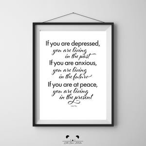 May include: A framed print with a white background and black text. The quote reads: "If you are depressed, you are living in the past. If you are anxious, you are living in the future. If you are at peace, you are living in the present." - Lao Tzu.