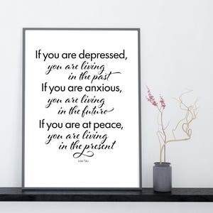 May include: A framed print with a white background features a quote by Lao Tzu: "If you are depressed, you are living in the past. If you are anxious, you are living in the future. If you are at peace, you are living in the present."