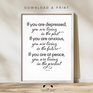 May include: A framed print with the quote "If you are depressed, you are living in the past. If you are anxious, you are living in the future. If you are at peace, you are living in the present." by Lao Tzu. The words are in black on a white background.