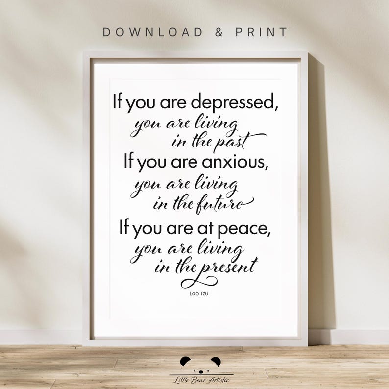 May include: A framed print with the quote "If you are depressed, you are living in the past. If you are anxious, you are living in the future. If you are at peace, you are living in the present." by Lao Tzu. The words are in black on a white background.