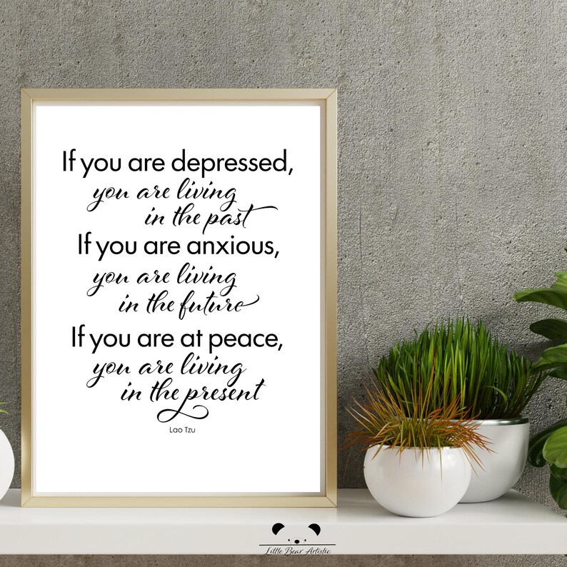 May include: A framed print with a white background and black calligraphy. The text reads: "If you are depressed, you are living in the past. If you are anxious, you are living in the future. If you are at peace, you are living in the present." The quote is attributed to Lao Tzu.