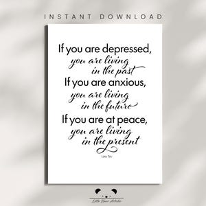 May include: A white print with black calligraphy text. The text reads: "If you are depressed, you are living in the past. If you are anxious, you are living in the future. If you are at peace, you are living in the present." The quote is attributed to Lao Tzu.
