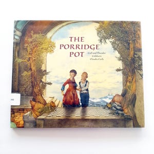 Peut inclure: Couverture du livre "The Porridge Pot" avec une illustration de deux enfants sur un chemin pavé. L'œuvre d'art est une peinture détaillée aux tons chauds, représentant une scène de conte de fées avec des arbres et une arche, avec du texte.