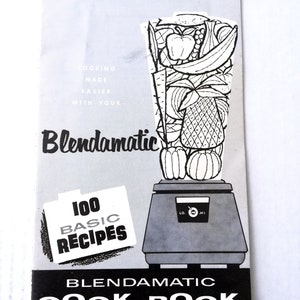 Op de afbeelding: Een zwart-witte illustratie van een blender met een verscheidenheid aan fruit en groenten erin. De tekst "Blendamatic" is geschreven in een vetgedrukt, cursief lettertype. De tekst "100 Basic Recipes" is geschreven in een witte doos met een zwarte rand. De tekst "Blendamatic Cook Book" is geschreven in een zwarte doos met een witte rand.