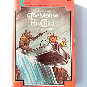 Pode incluir: Uma capa de livro vermelha e branca com uma ilustração de um rato e seu filho em um barco passando por uma cachoeira. O título do livro é "The Mouse and His Child" de Russell Hoban. A capa do livro também inclui o texto "Now a Very Special Motion Picture!" e "Pictures by Lillian Hoban".