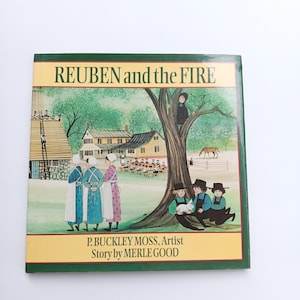 May include: A hardcover book titled "REUBEN and the FIRE" with a green border. The cover illustration depicts a rural scene with figures, a tree, and a house. The author and artist's names are also visible.