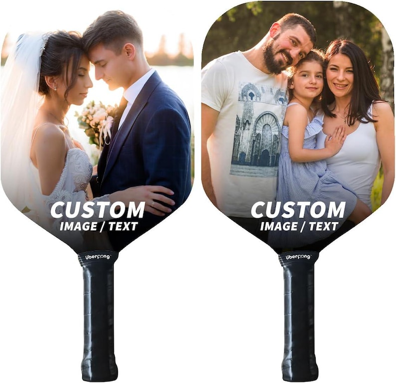May include: Two custom designed pickleball paddles with images of a wedding couple and a family. The paddles are black with white text that says "CUSTOM IMAGE / TEXT".