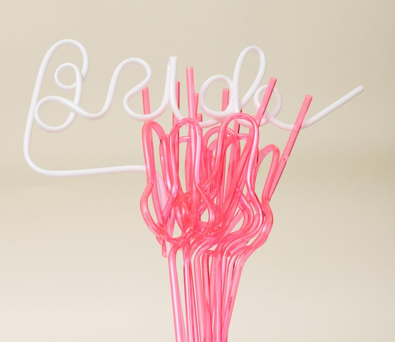 May include: Pink and white plastic straws shaped to spell out the word "Bride".