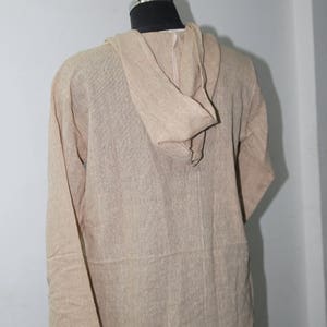 Op de afbeelding: Een beige longsleeve met capuchon en een losse pasvorm. Het shirt is gemaakt van een zachte, lichte stof.