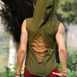 Op de afbeelding: Een groen, mouwloos, getailleerd hooded top met een uitgesneden ontwerp op de rug. Het topje wordt gedragen over een bordeauxrode broek.
