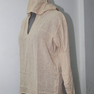 Op de afbeelding: Een beige tuniek met capuchon en lange mouwen. De tuniek is gemaakt van een zachte, lichte stof en heeft een losse pasvorm.