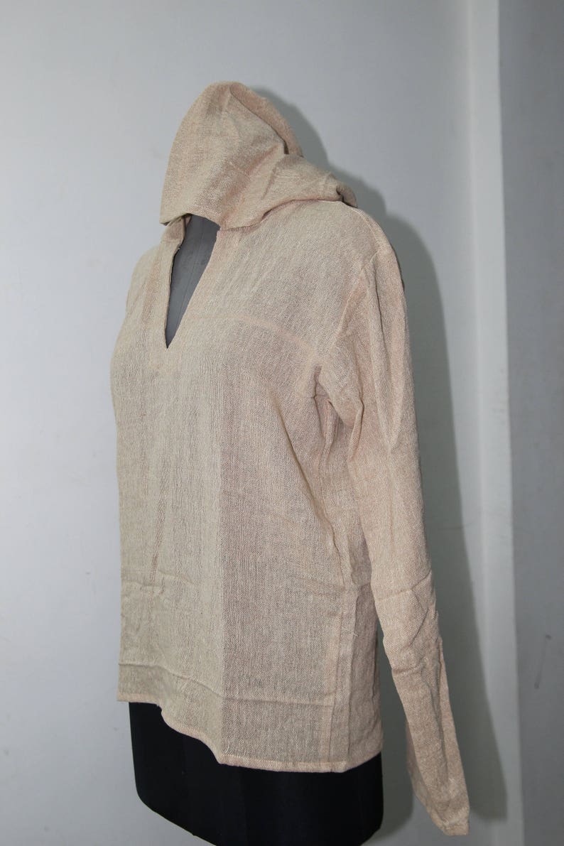 Op de afbeelding: Een beige tuniek met capuchon en lange mouwen. De tuniek is gemaakt van een zachte, lichte stof en heeft een losse pasvorm.