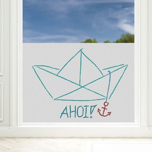 Op de afbeelding: Een turquoise papieren bootje met een rood anker en het woord "AHOI!" getekend op een witte achtergrond.