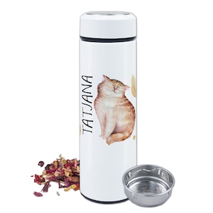 Op de afbeelding: Witte geïsoleerde waterfles met een illustratie van een lachende oranje tabby kat en de naam "TATJANA" in het zwart. Een roestvrijstalen thee-infuser en gedroogde rozenblaadjes zijn ook zichtbaar.