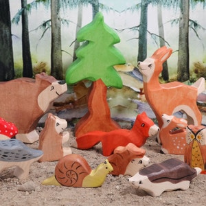 May include: A set of wooden animal figurines, including a bear, deer, fox, squirrel, owl, snail, hedgehog, and mushrooms. The figurines are painted in realistic colors and have detailed features. The set is perfect for imaginative play and would make a great addition to any child's toy collection.