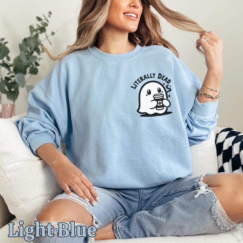 Pu&ograve; includere: Felpa blu chiaro con un fantasma che tiene una tazza di caff&egrave; e la scritta "Literally Dead" sul davanti.