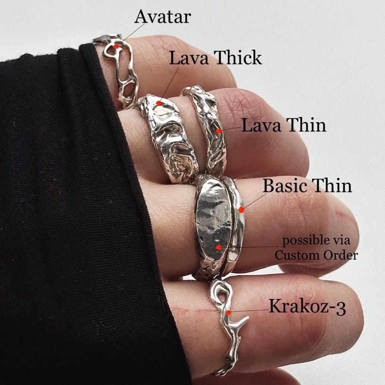 Close lifestyle photo of a left hand wearing a mixed solid 925 sterling silver look, with labels naming each ring. From pinky to thumb: openwork Avatar; chunky, heavy freeform Lava Thick with uneven wide lava relief; unique wavy Lava Thin with irregular texture; smooth slim Basic Thin beside a wider custom-order band; and openwork Krakoz-3. The Lava Thick and Thin designs add fluid abstract contrast to the stacked silver set.