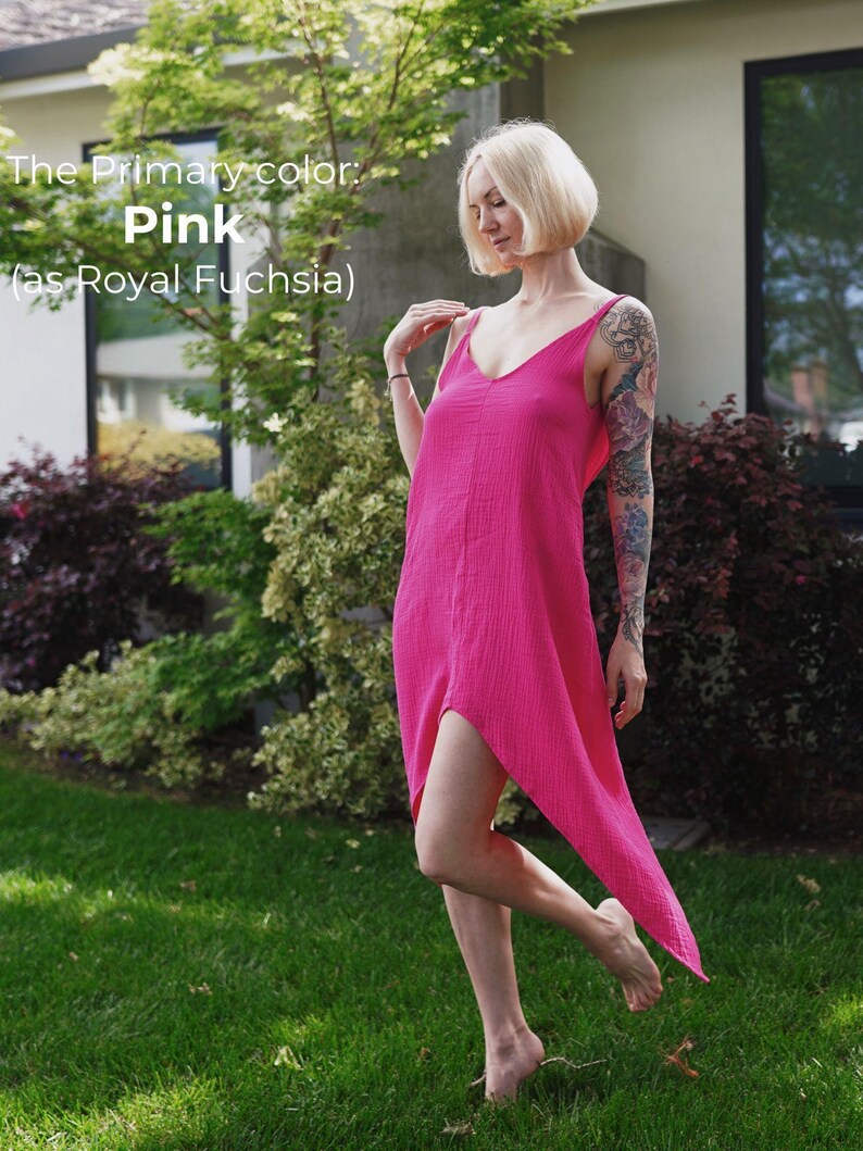 A woman in a pink dress stands in a grassy area, with a house and trees in the background.