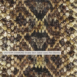 May include: Close-up of Eastern Diamond snake skin pattern. The pattern features a repeating design of diamond shapes in shades of brown, black, and tan. The text "EASTERN DIAMOND Snake Skin (label cast) Pen Blanks" is visible.