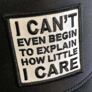 May include: Black and white embroidered patch with the text "I CAN'T EVEN BEGIN TO EXPLAIN HOW LITTLE I CARE".