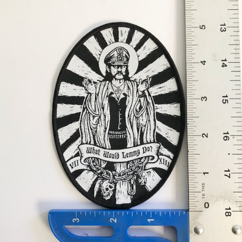 May include: Black and white embroidered patch of a man in a military uniform with a crown and the text "What Would Lemmy Do?"  The patch is oval shaped and has a black and white sunburst design.