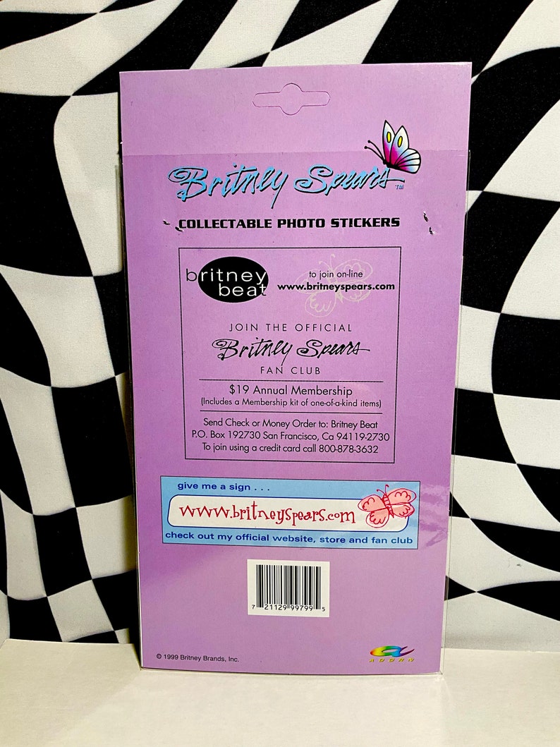 May include: A collectible photo sticker sheet featuring the name "Britney Spears" in a stylized font, with a butterfly graphic. The sheet includes text for a fan club and website address.