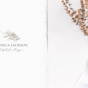 May include: A white background with a logo for a lifestyle blogger named Monica Jackson. The logo features a watercolor illustration of a branch with leaves. A cup of coffee with a heart design in the foam sits on a white saucer next to a magazine with the word "Vogue" visible on the cover. A sprig of dried eucalyptus is in the upper right corner of the image.