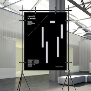 Puede incluir: Un póster en blanco y negro con el texto "DANGER ROBOTS!" y una advertencia para mantener una distancia segura de todo el personal mecanizado. El póster se muestra en un trípode en un entorno moderno y minimalista.